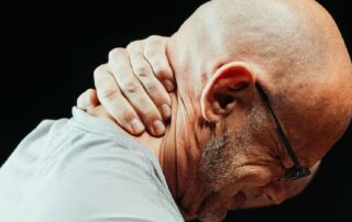 man holding the back of his neck while figuring out the difference between triggerpoints and knots